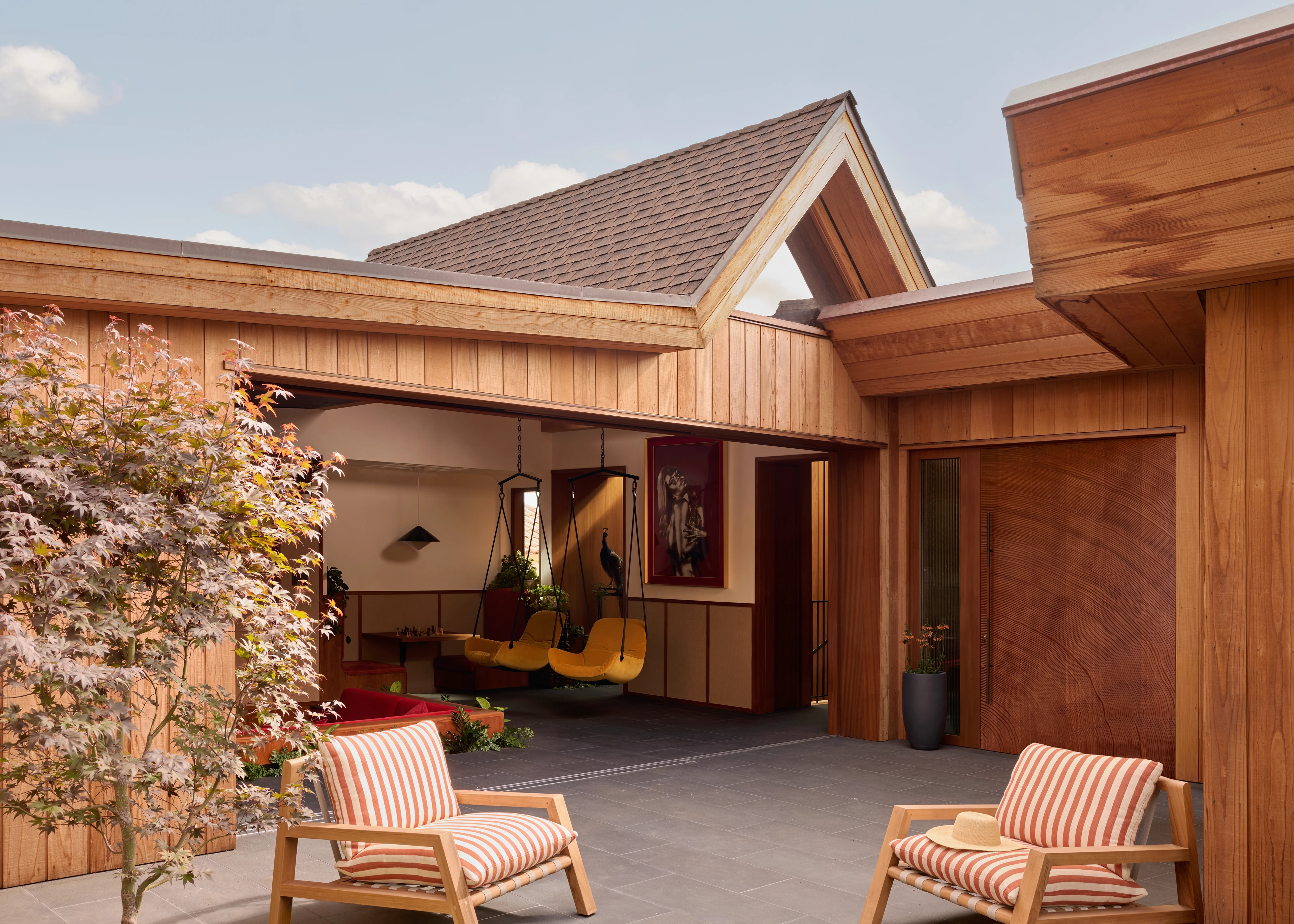 Retro Space House — timber courtyard with hanging chairs