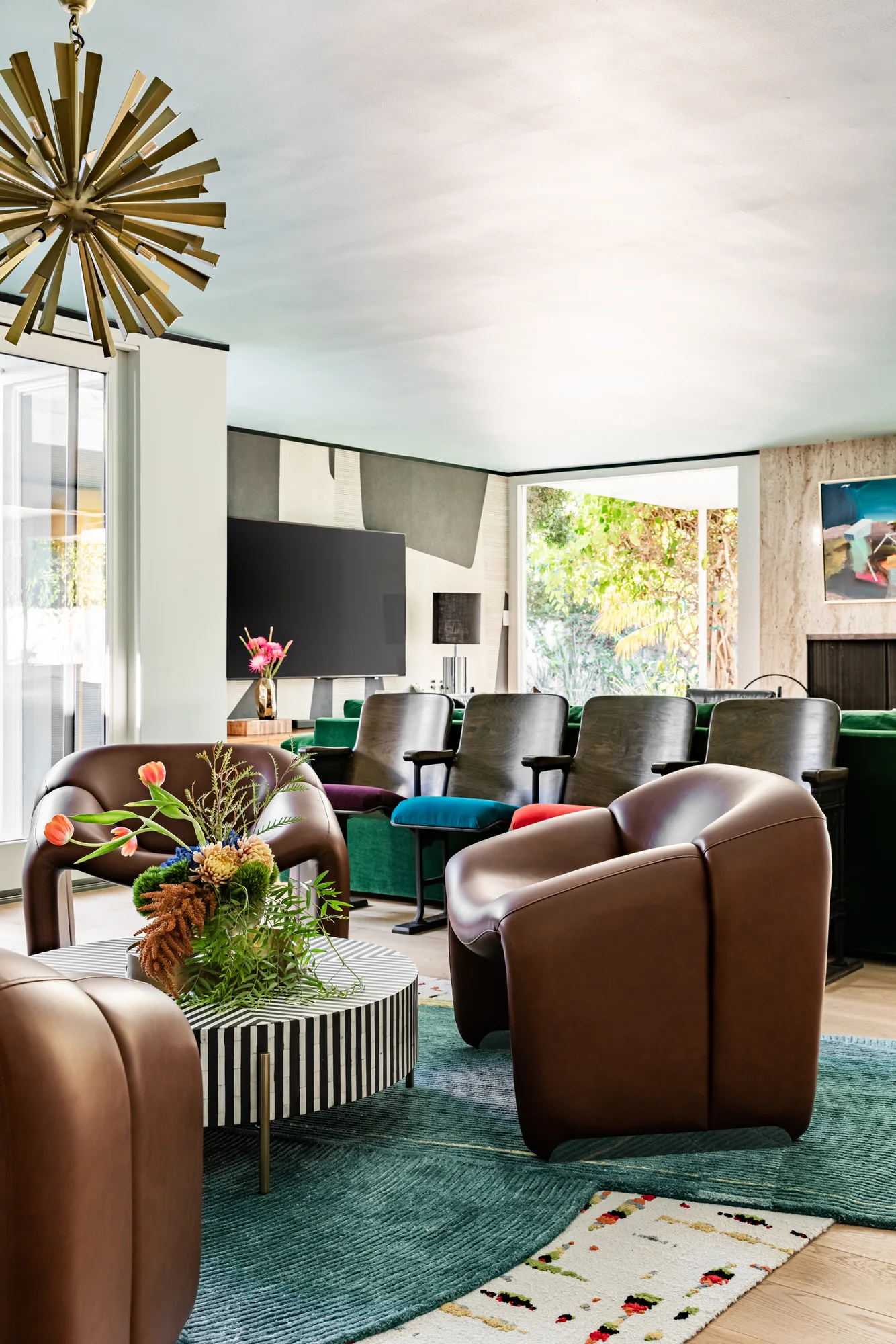 Leather lounge chairs around a fluted coffee table on a teal rug