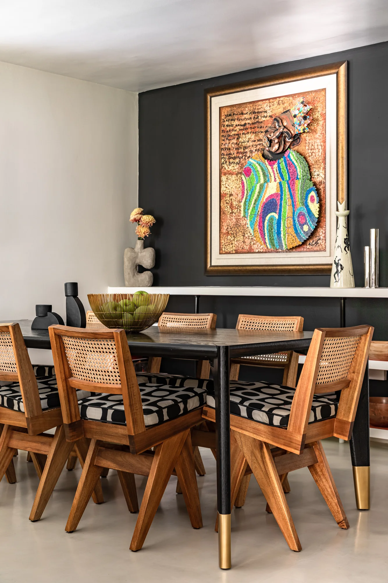 Chrome tulip chair against an ochre graphic wallcovering