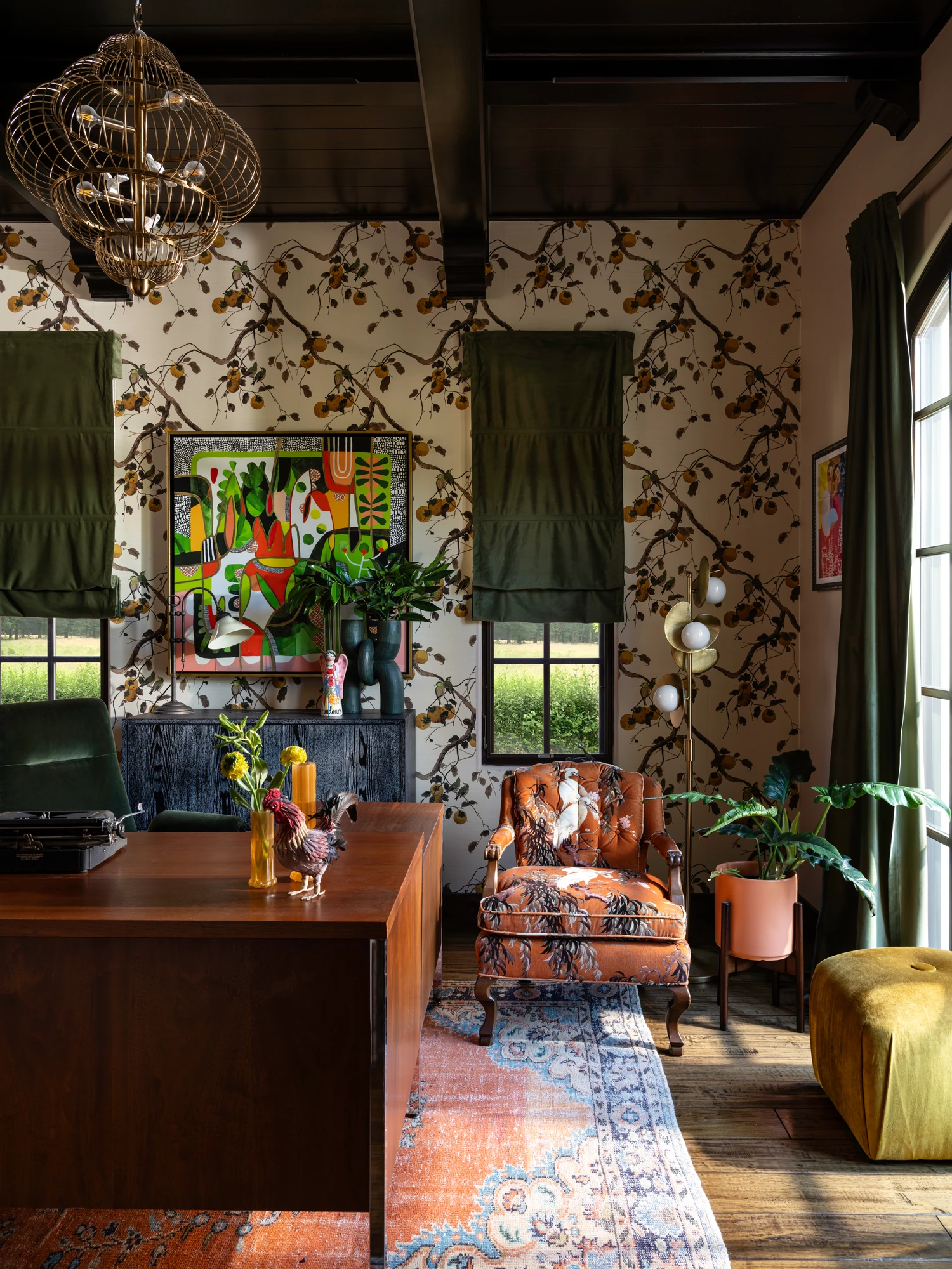 The study in botanical wallpaper, with green shades, a patterned armchair and a chartreuse ottoman