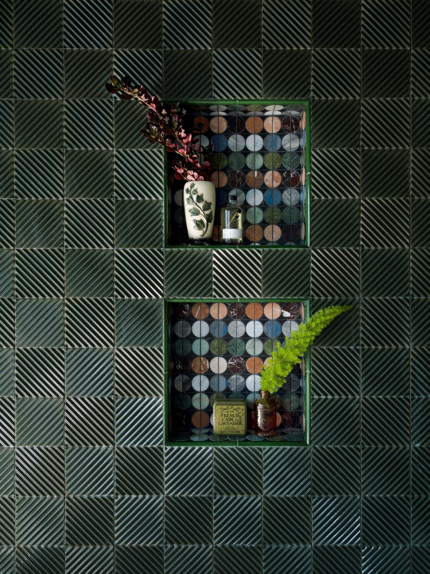 Glazed green tile wall with recessed niches