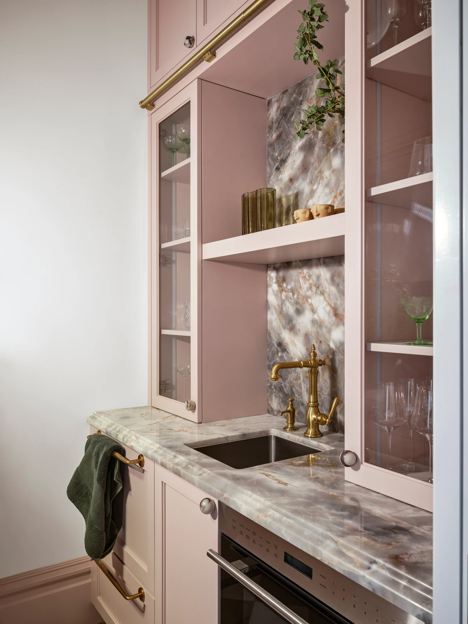 Butler’s pantry with a marble backsplash and glazed cabinetry