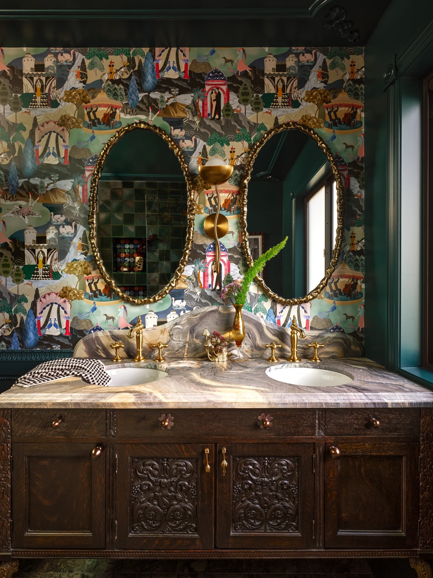 Twin oval mirrors above the antique vanity, against hand-painted chinoiserie