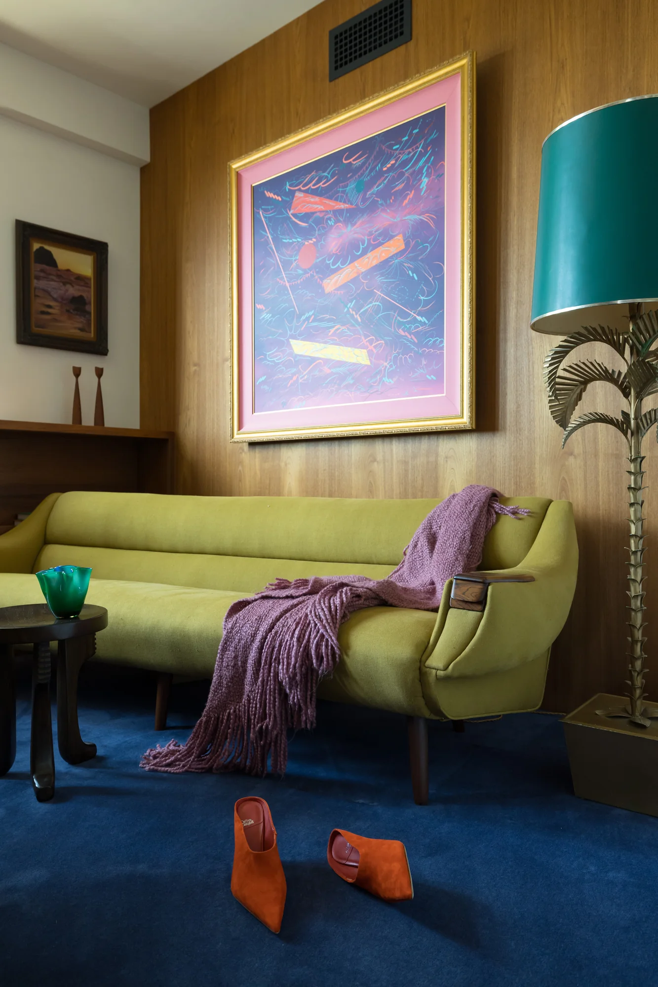 Chartreuse sofa with a lavender throw under an abstract painting