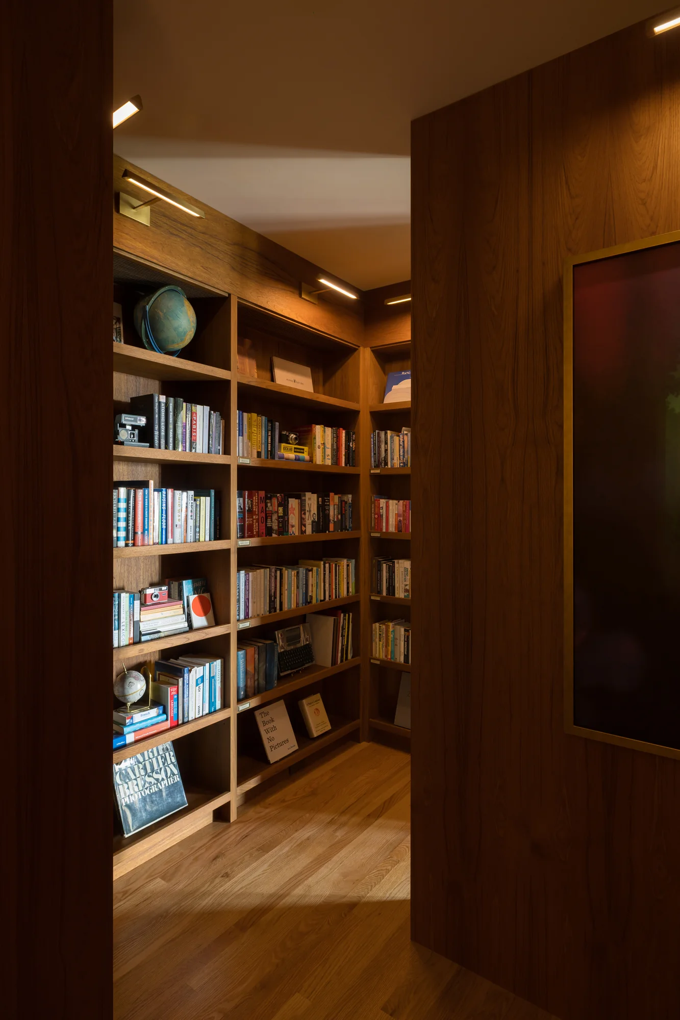 Book-lined passage looking through to a lit alcove