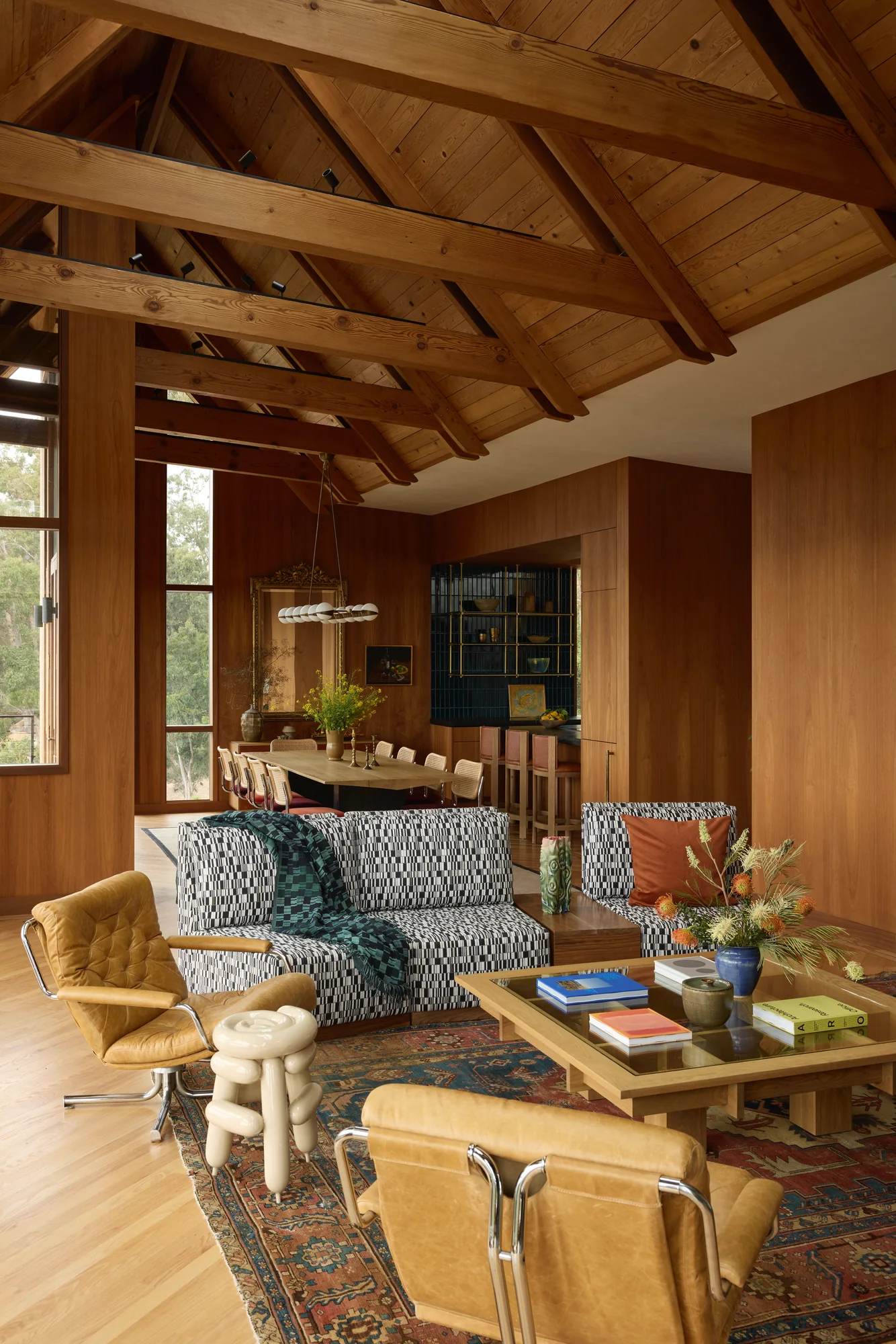Living room opening to the hillside through a wall of windows