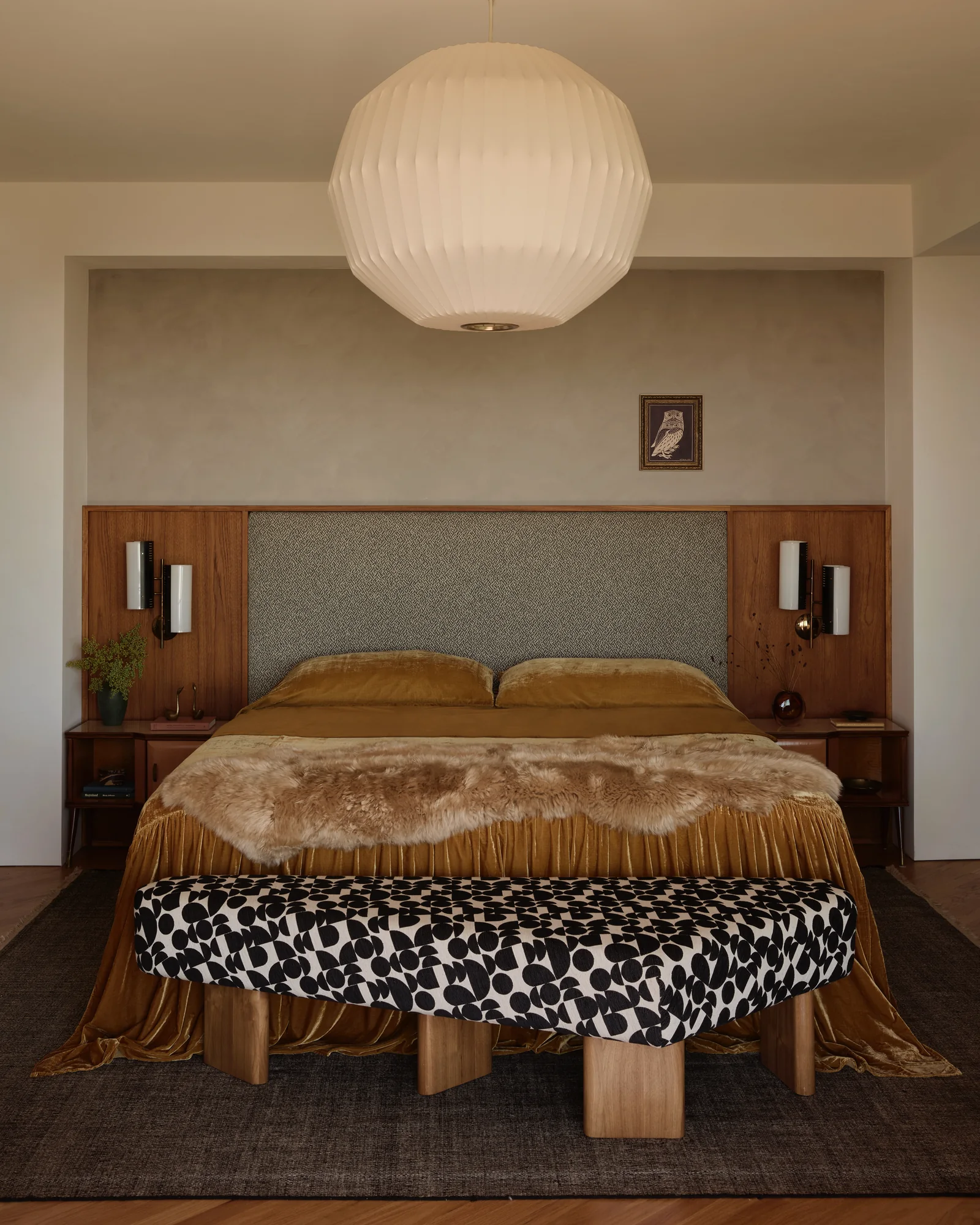 Primary bedroom with a paper globe pendant and an upholstered headboard