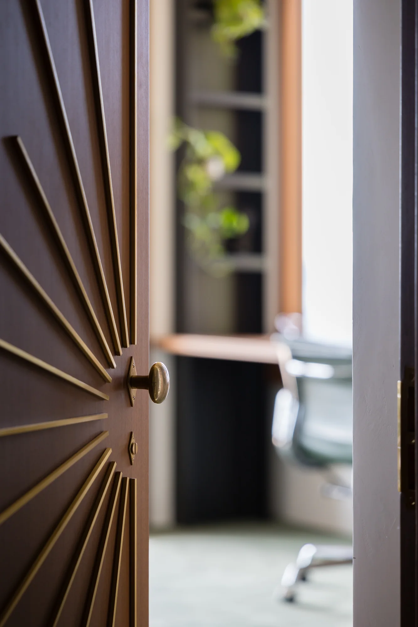 Sunburst-carved door detail with the study beyond